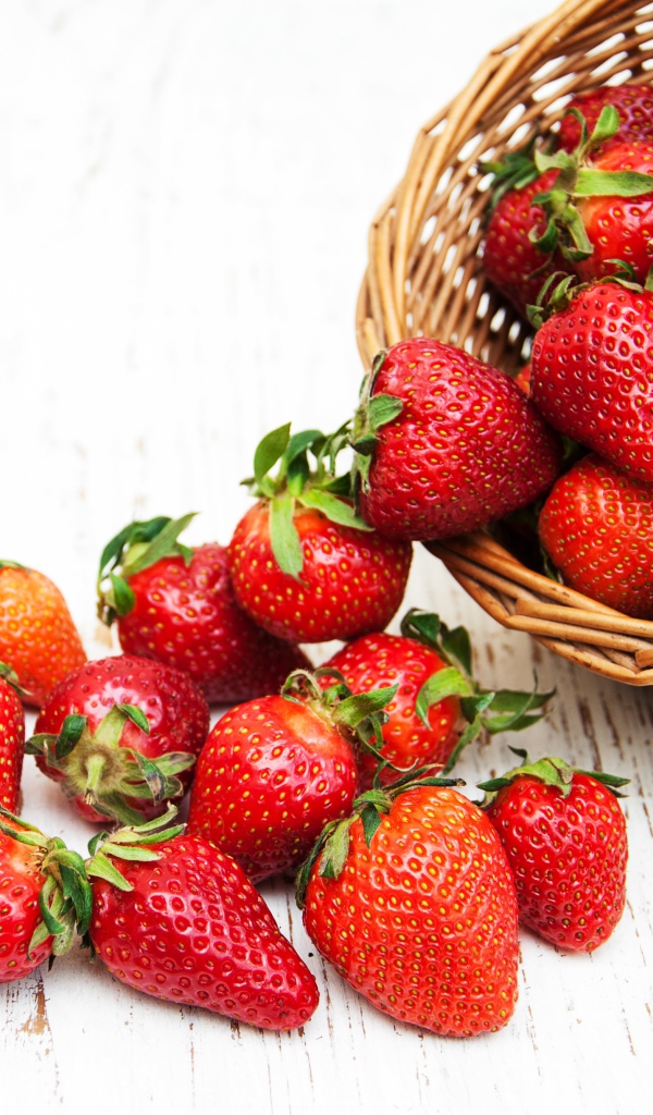 Клубника в корзине на деревянном столе