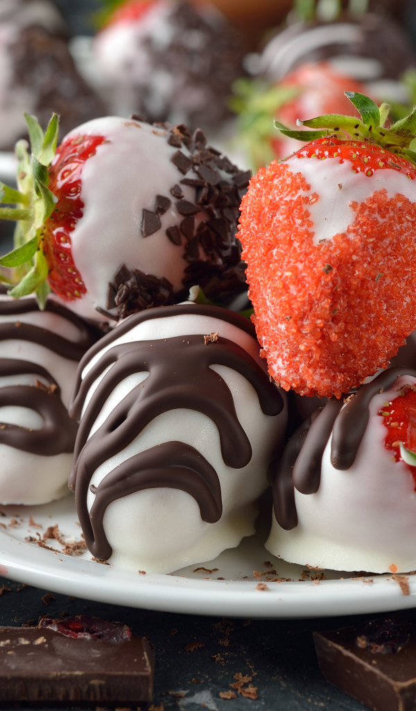 Клубника в шоколаде и сахаре на белой тарелке