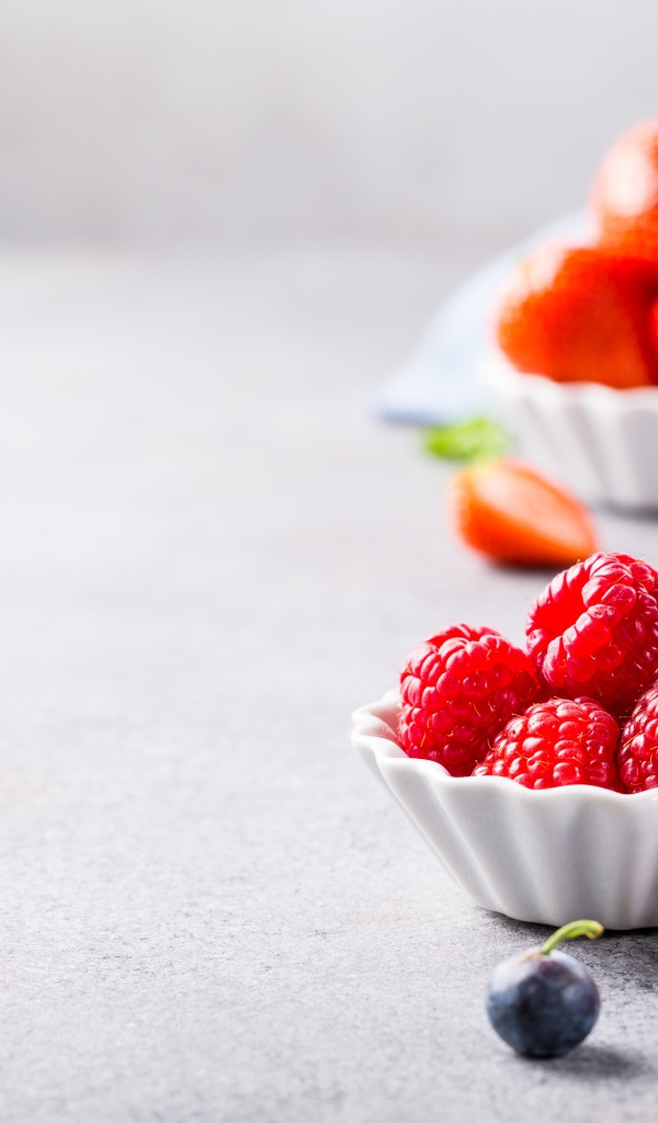 Ягоды клубники, малины и черники на столе 