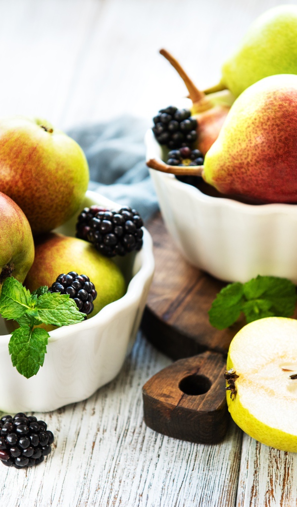 Вкусные груши на столе с ягодами ежевики