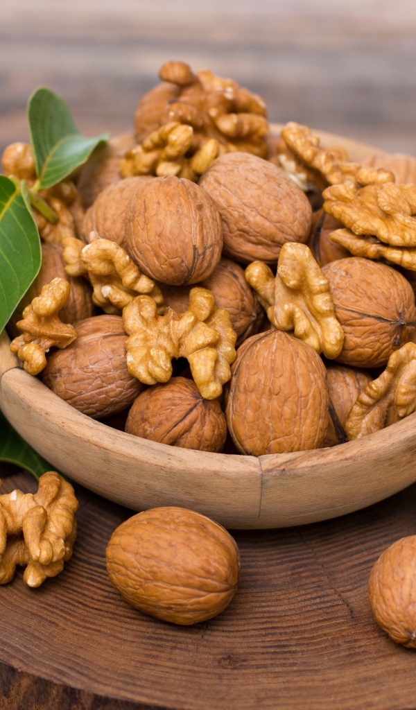 Грецкие орехи в миске на деревянной доске