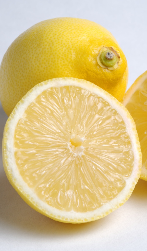 Желтые кислые лимоны на сером фоне