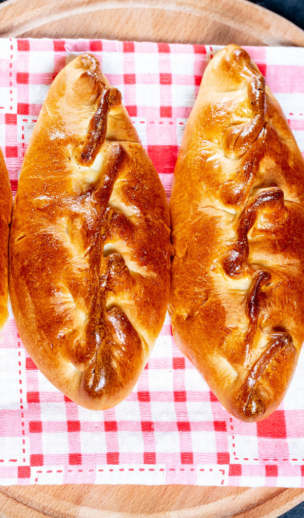 Аппетитные румяные пирожки лежат на полотенце 