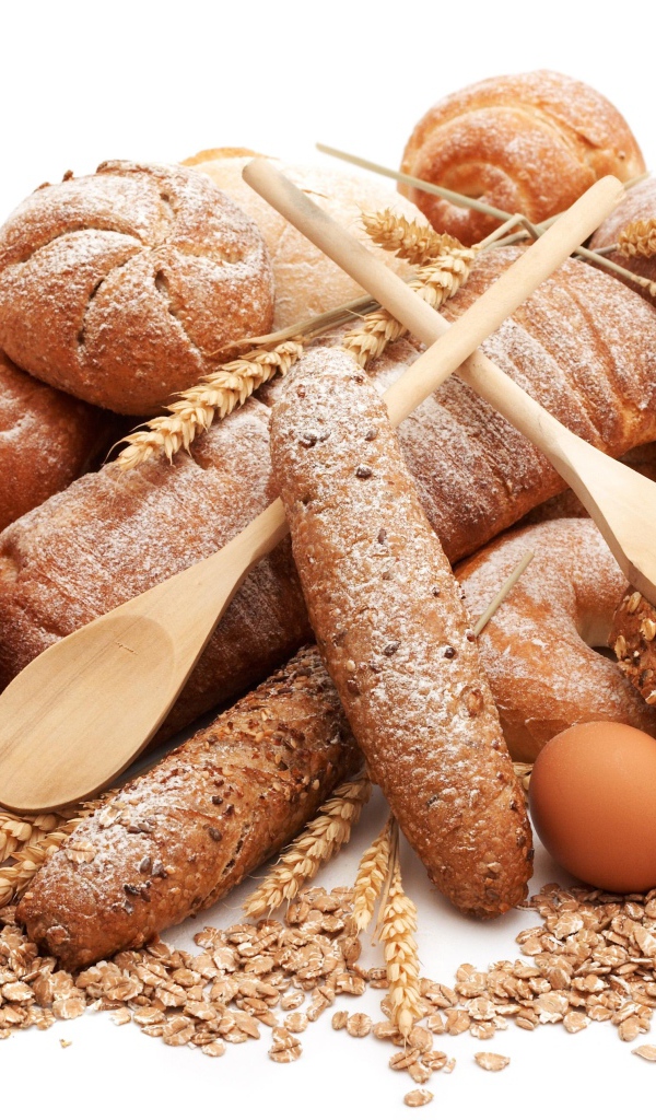 Свежий хлеб на белом фоне с яйца, чашкой молока и овсянкой