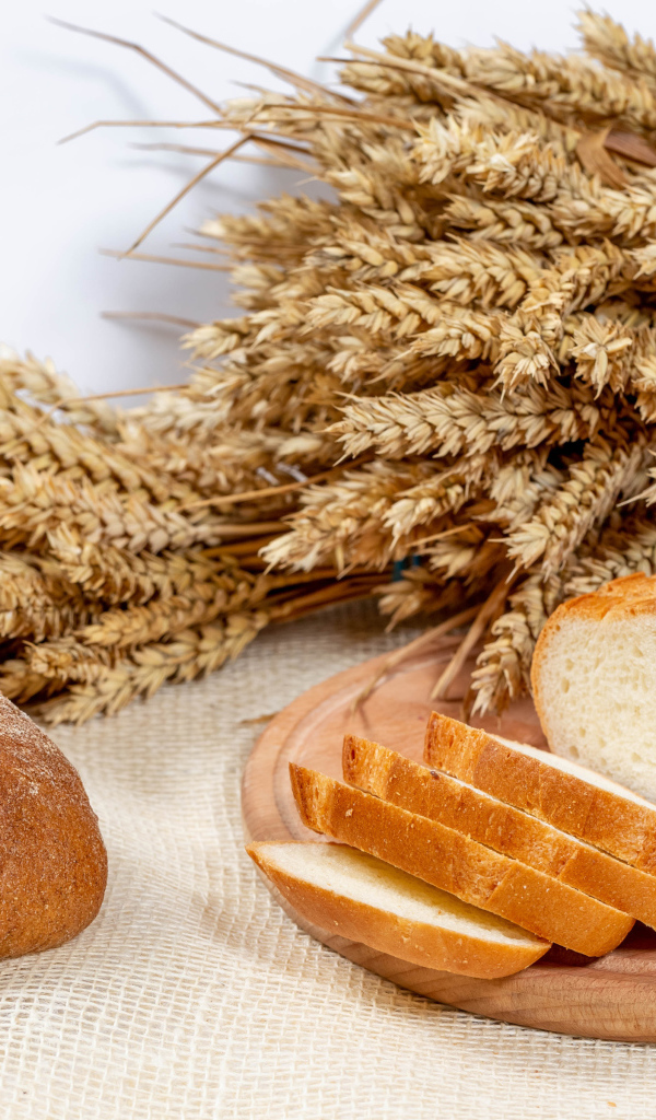 Свежий ароматный хлеб на столе с колосьями пшеницы