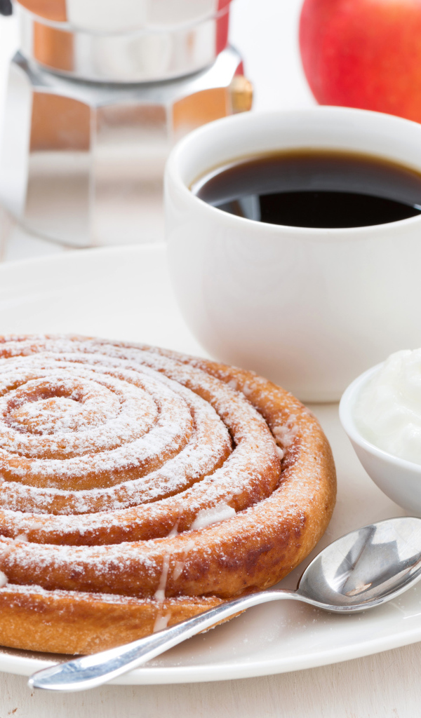 Чашка кофе на тарелке с выпечкой и сливками