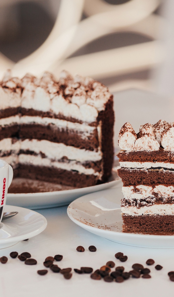 Аппетитный торт с чашкой кофе на столе