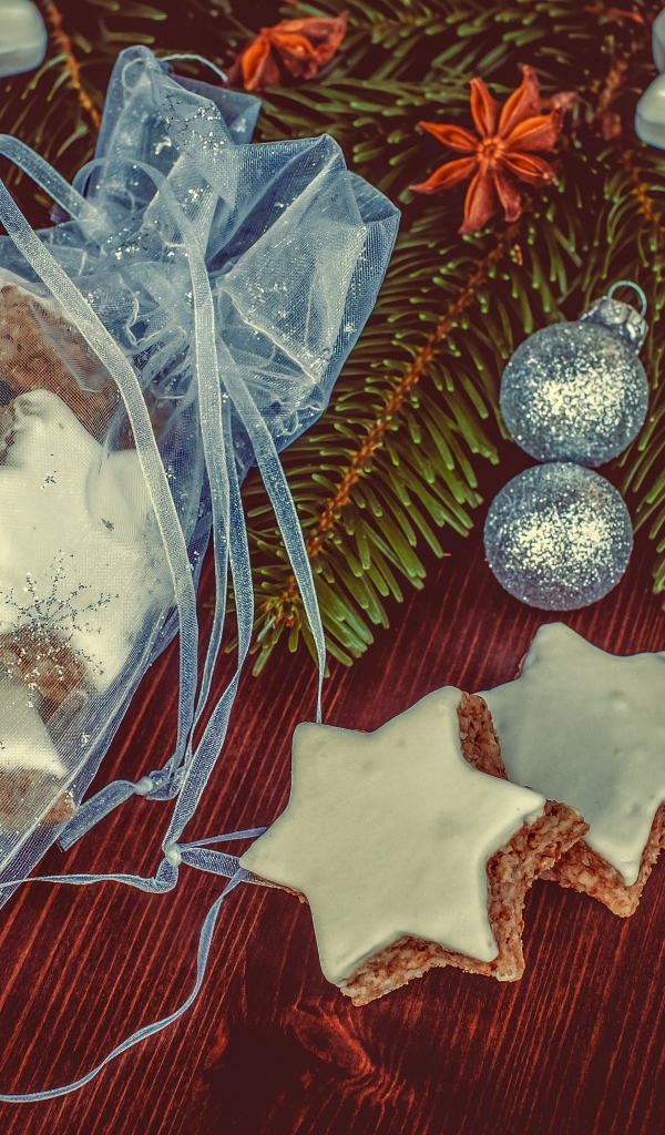 Аппетитное печенье звездочки в мешочке на столе с еловой веткой
