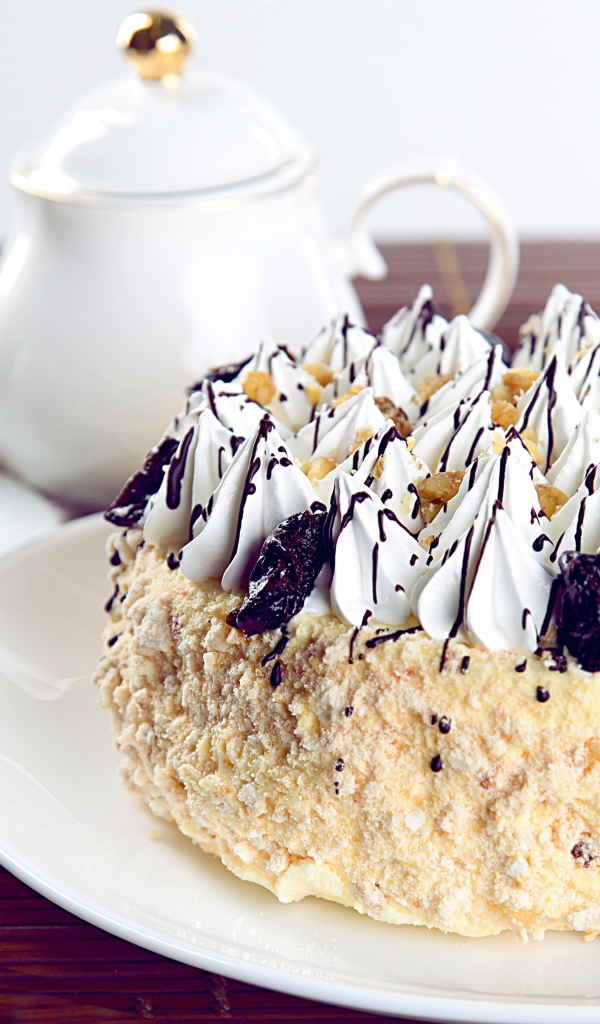 Красивый праздничный торт с безе на столе с чаем