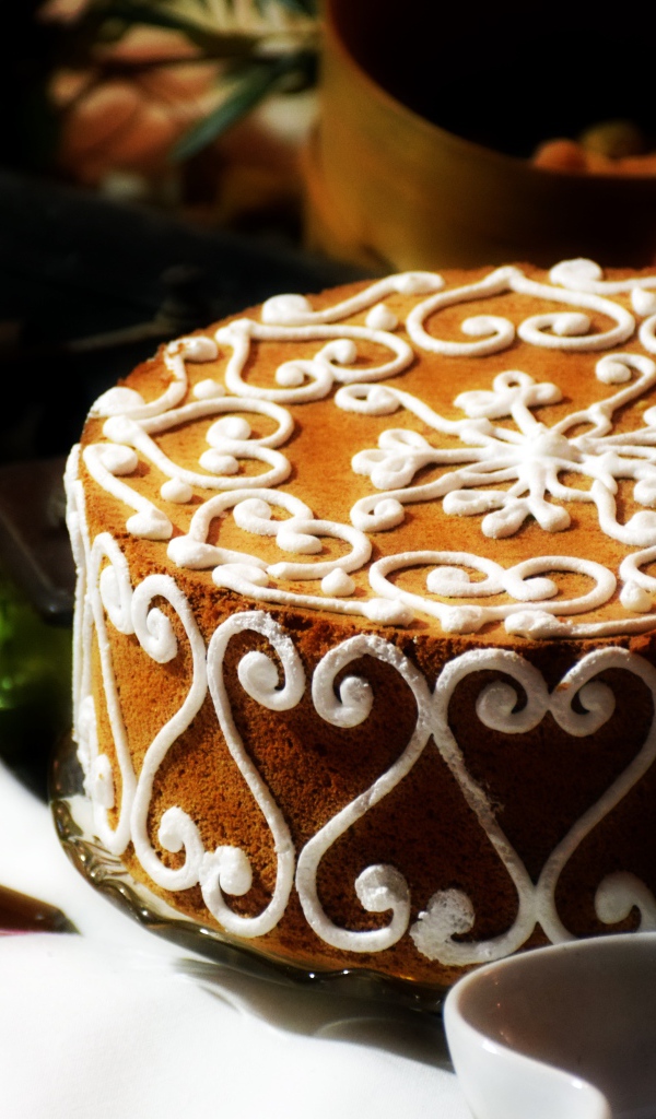 Красивый торт с белым рисунком  на столе