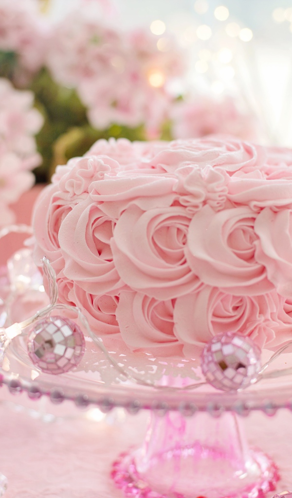 Красивый розовый торт на столе с цветами