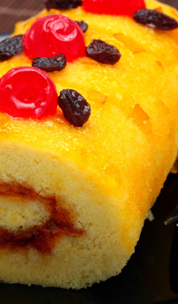 Бисквитный рулет с сухофруктами на тарелке с вилкой