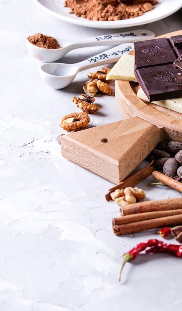 Черный и молочный шоколад на столе с орехами