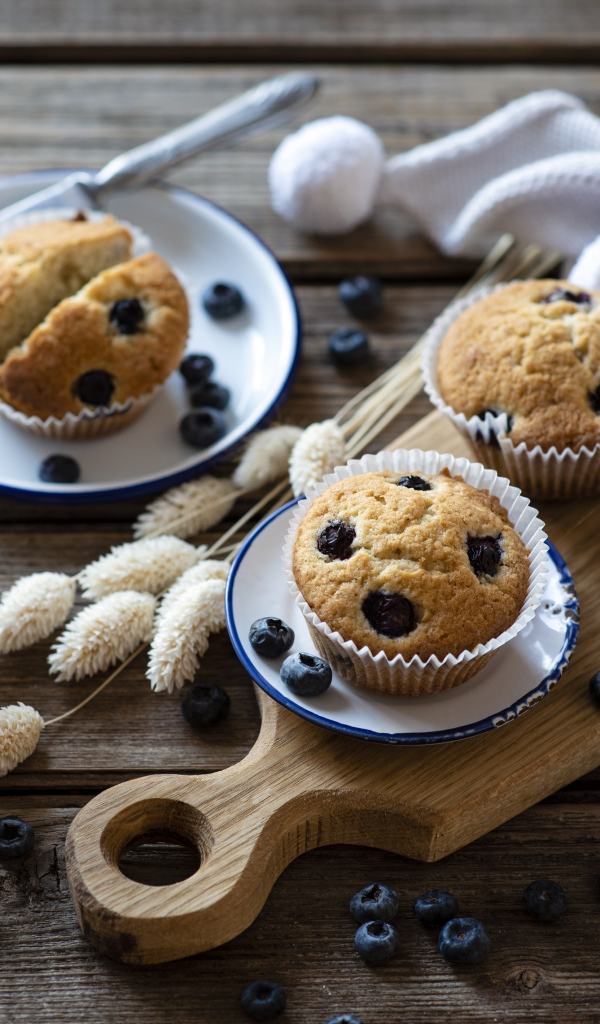 Кексы с черникой на столе с колосьями и кофе
