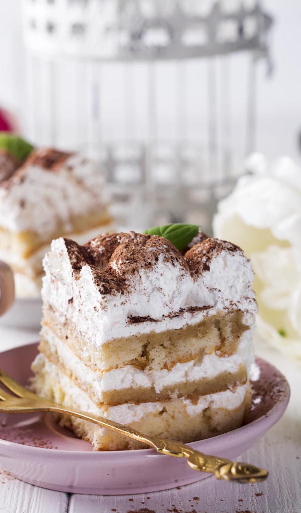 Пирожное на столе с кофе и цветами 