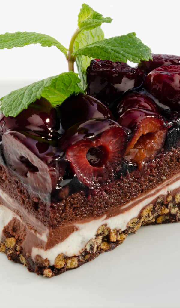 Пирожное с черешней и листиками мяты на сером фоне