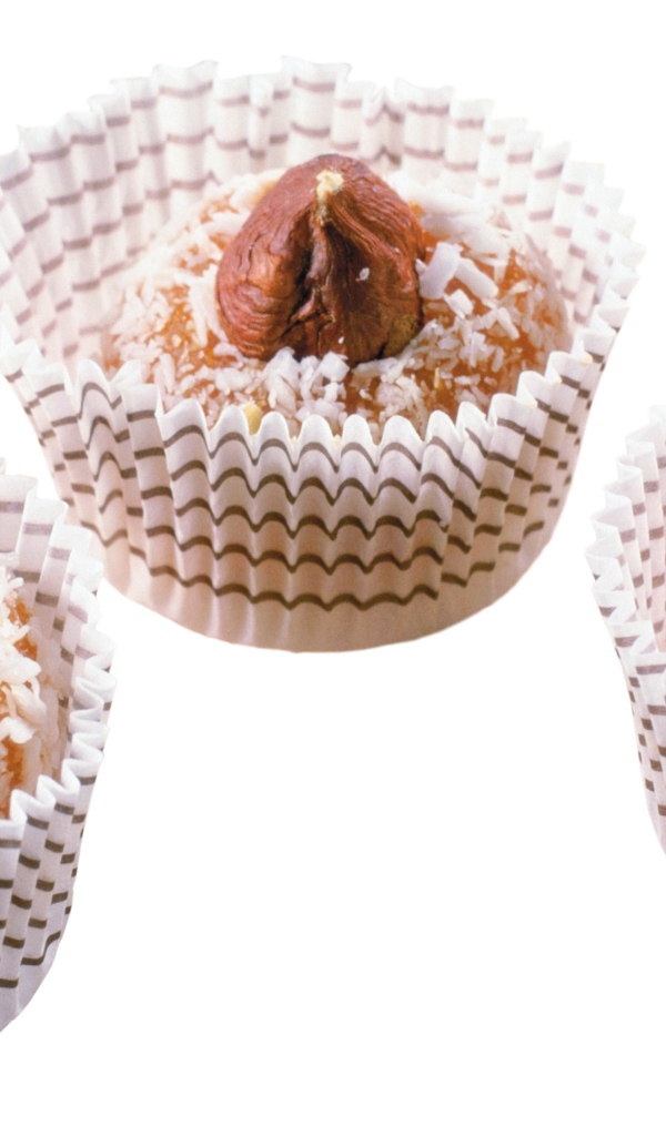 Конфеты с кокосовой стружкой и орехами на белом фоне