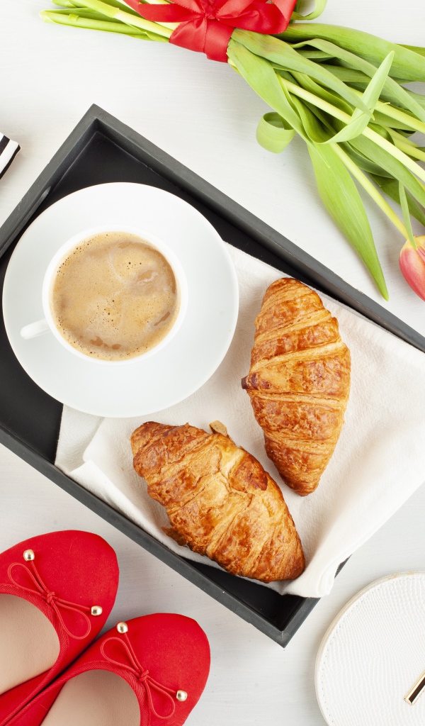 Кофе и круассаны на столе с букетом для любимой