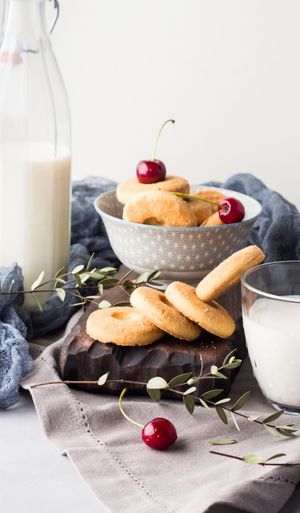 Печенье на столе с молоком и черешней
