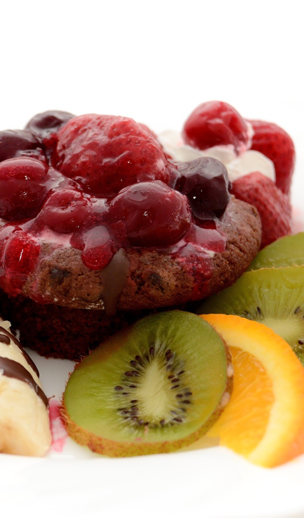 Печенье с вареньем, кусочками банана, киви и апельсина на белом фоне