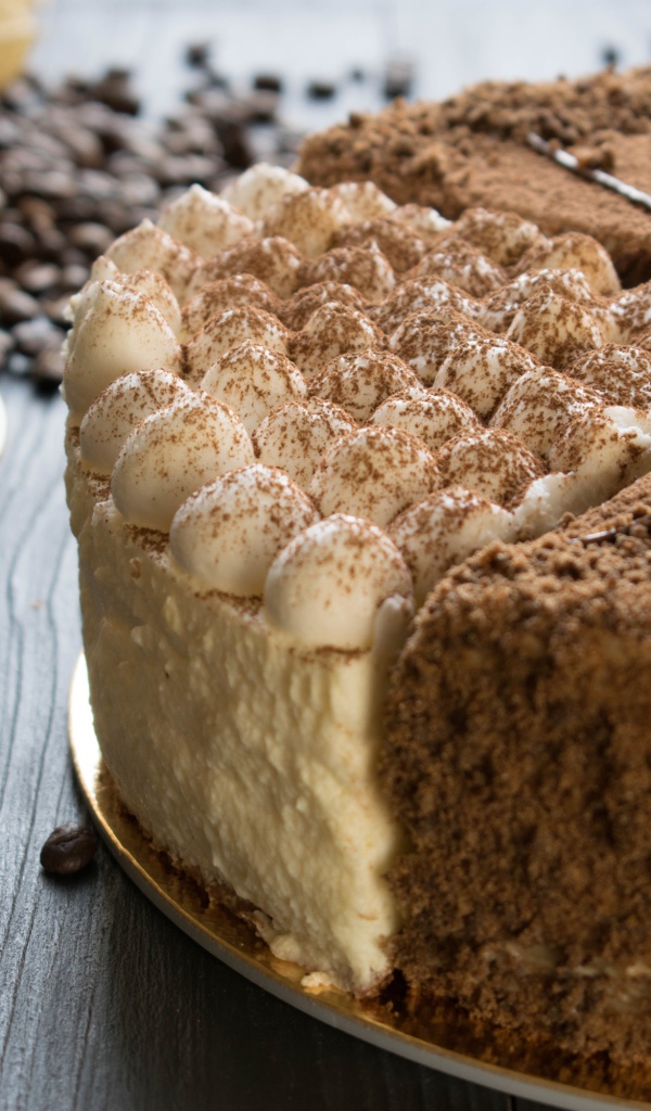 Вкусный торт с кремом и физалисом на столе с кофе