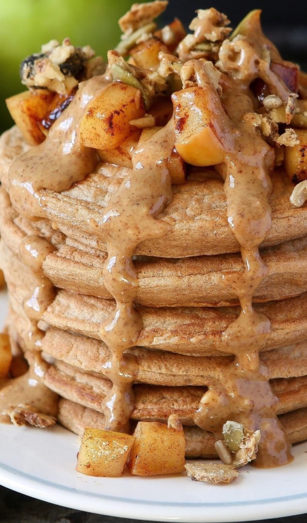 Вкусные оладьи с соусом и фруктами на столе с корицей