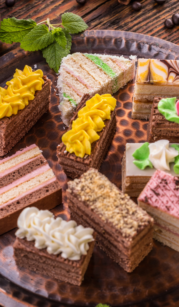 Разные вкусные пирожные на подносе 