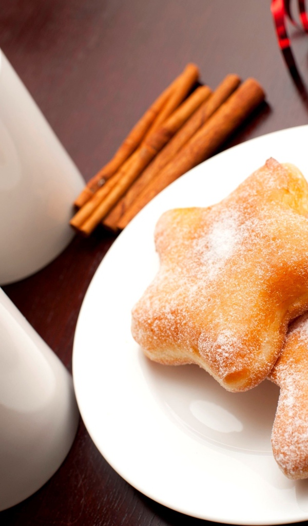 Пончики на столе с кофе и палочками корицы