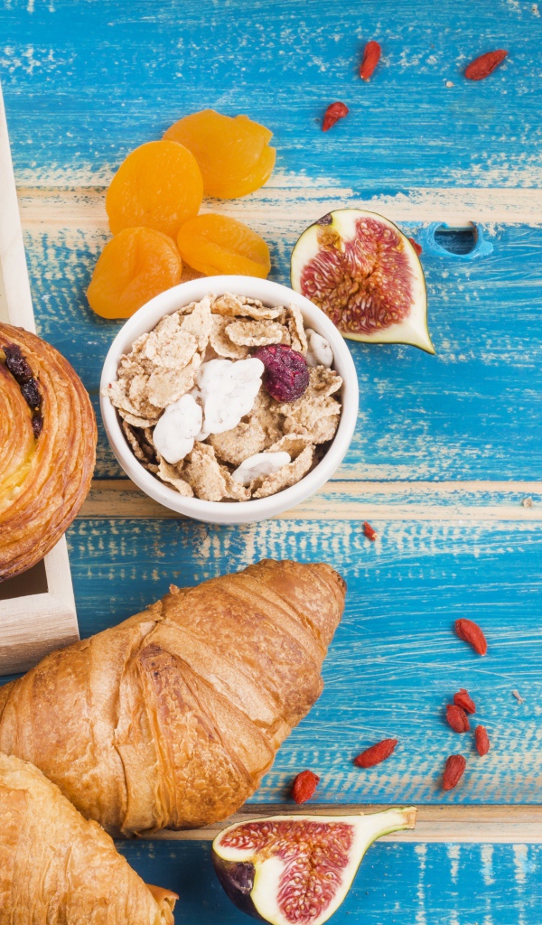 Свежая выпечка, молоко и мюсли на завтрак на столе