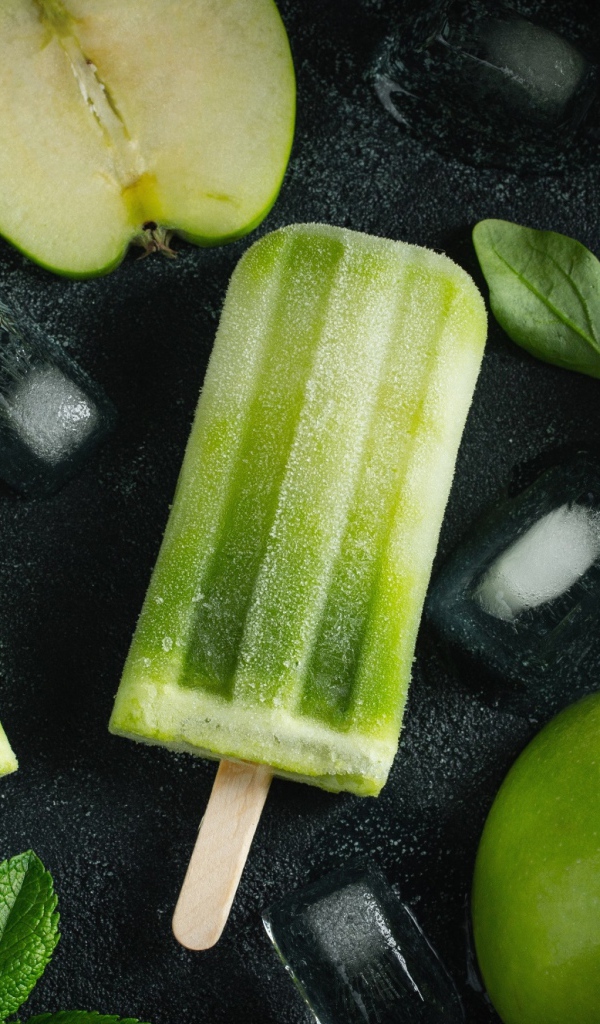 Зеленое фруктовое мороженое на столе с яблоками