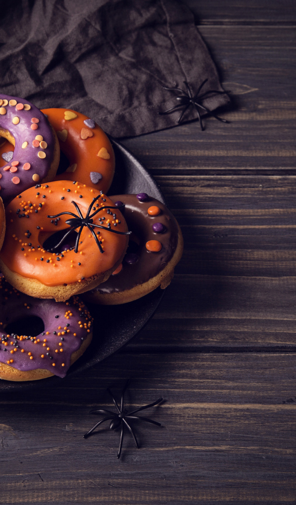 Пончики с глазурью на столе угощение на Хэллоуин 