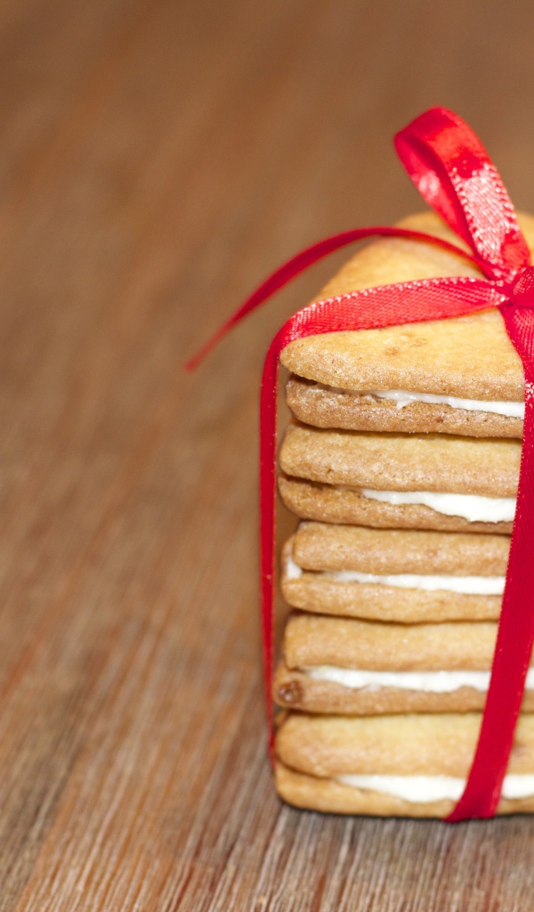 Печенье в форме сердца перевязано красной лентой 