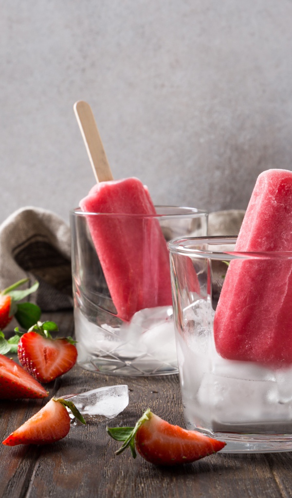 Фруктовое мороженое в стакане со льдом на столе с клубникой