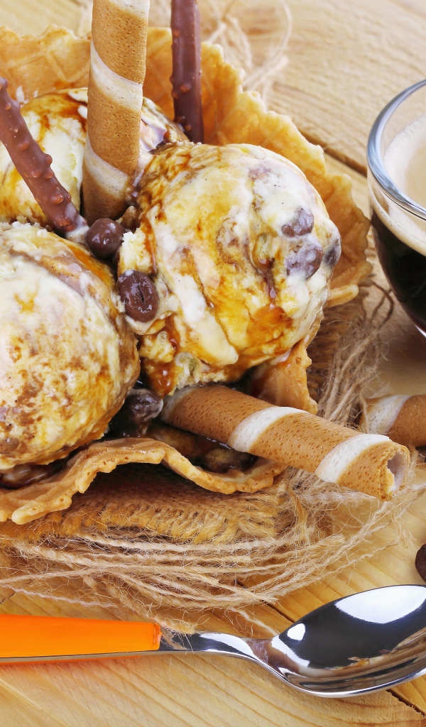 Мороженое с трубочками на столе с кофейными зернами и кофе