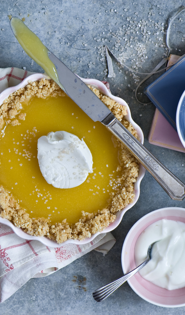 Лимонный пирог на столе с лимонами и сметаной