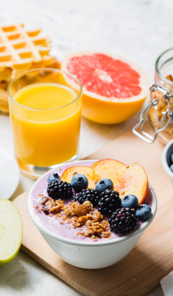 Мюсли с ягодами на столе с соком и кофе