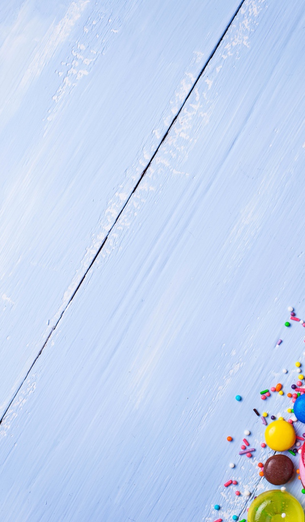 Разноцветные конфеты на голубом столе