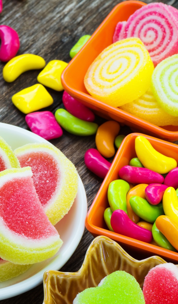 Разноцветный мармелад с конфетами на деревянном столе