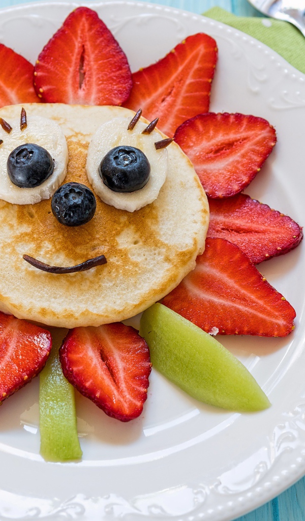 Оладьи с фруктами и ягодами на тарелке