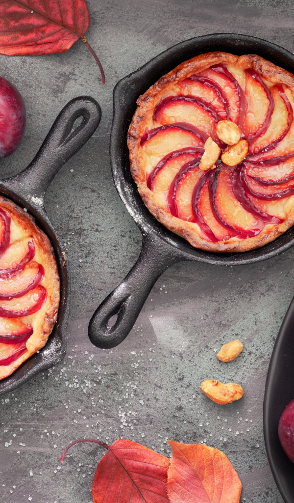 Пирог на столе с розовыми крупными сливами