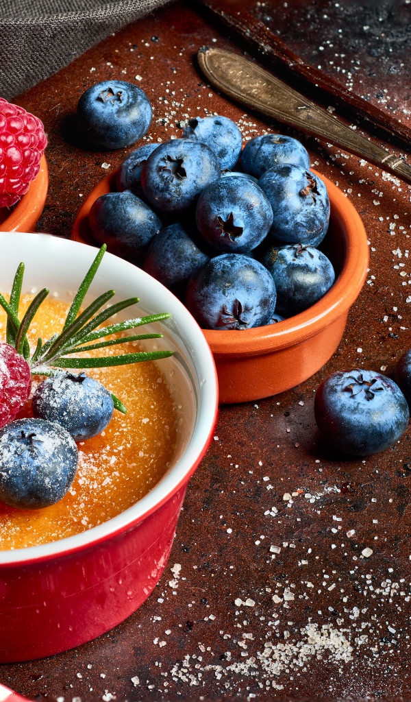 Пудинг на столе с ягодами малины и черники