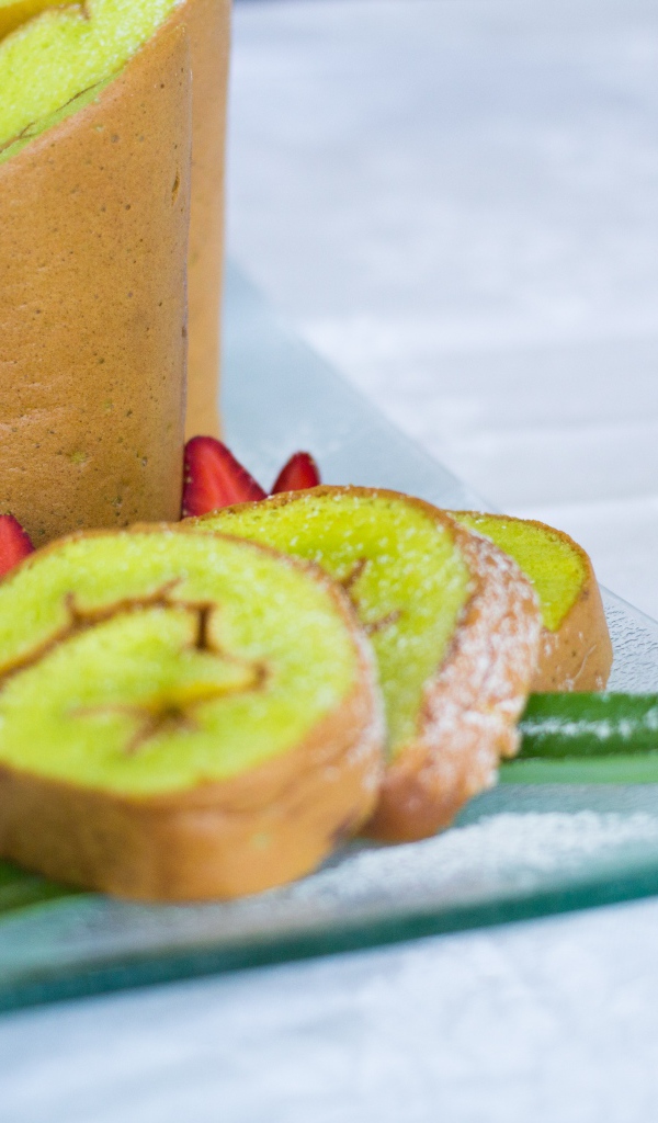 Рулет с сахарной пудрой и клубникой на столе