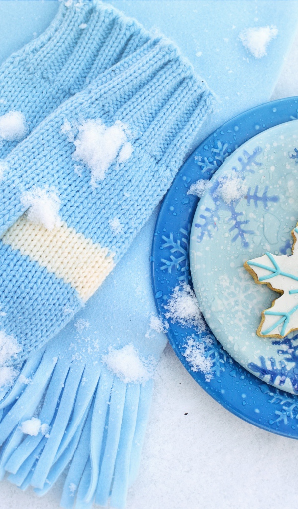 Печенье снежинки на снегу с шарфом и рукавицами