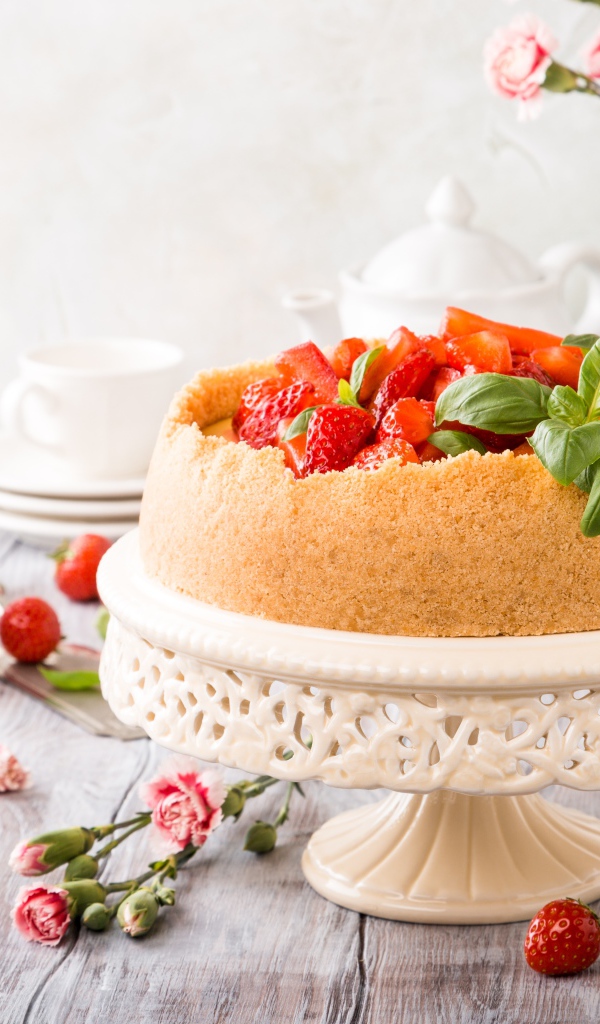 Песочный пирог с клубникой на столе с цветами гвоздики
