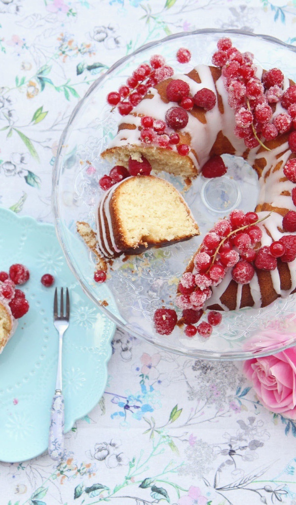 Сладкий кекс с красной смородиной на столе розовыми розами