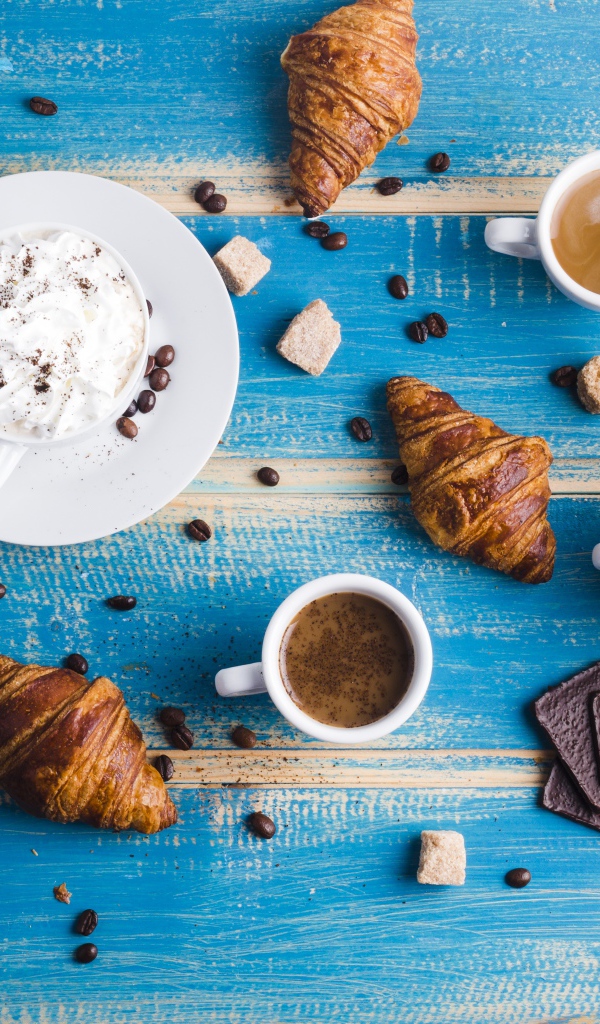 Сладости с кофе на голубом столе