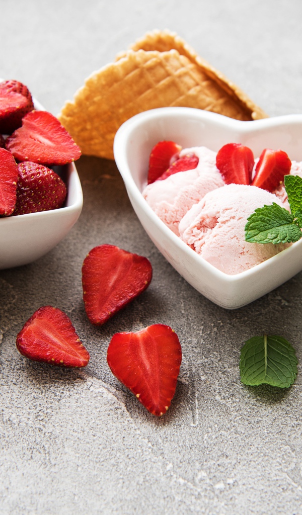 Вкусное мороженое на столе с клубникой и вафельными рожками