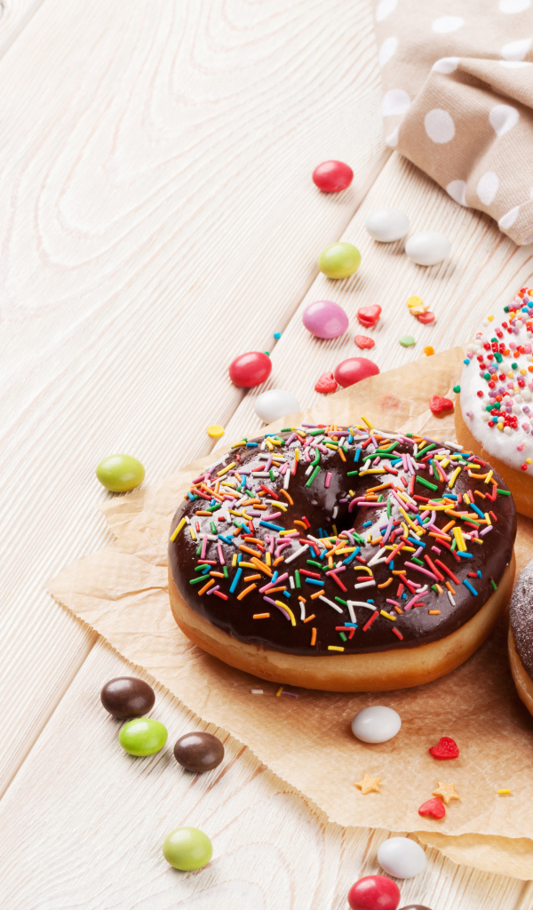 Три аппетитных пончика с глазурью на столе 