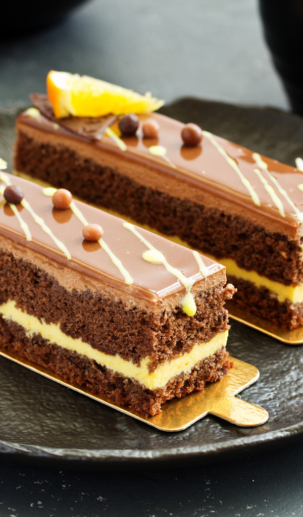 Два вкусных шоколадных пирожный на большой тарелке с вилкой