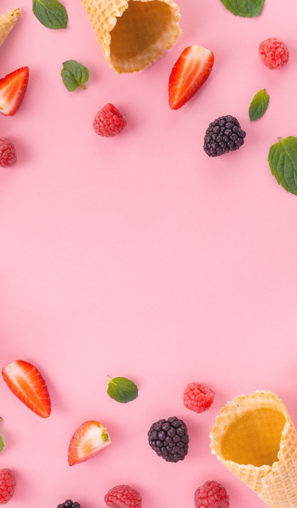 Вафельные рожки на розовом фоне с ягодами малины, клубники и ежевики